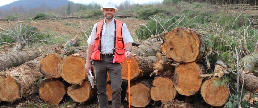 Chad Bolding stands with cut trees