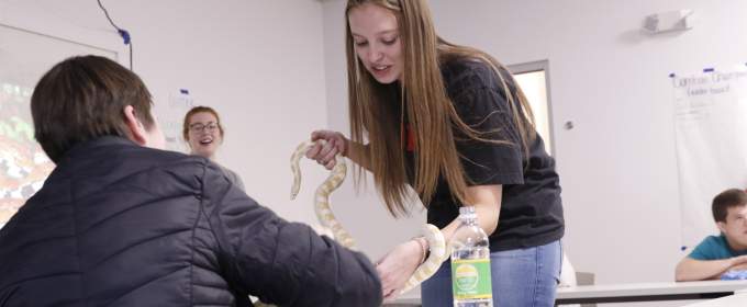 Cora Wall shows an albino snake to a student.